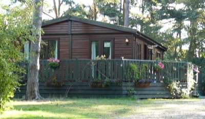 Mobile log cabin installation looks much better with service pipes covered over!